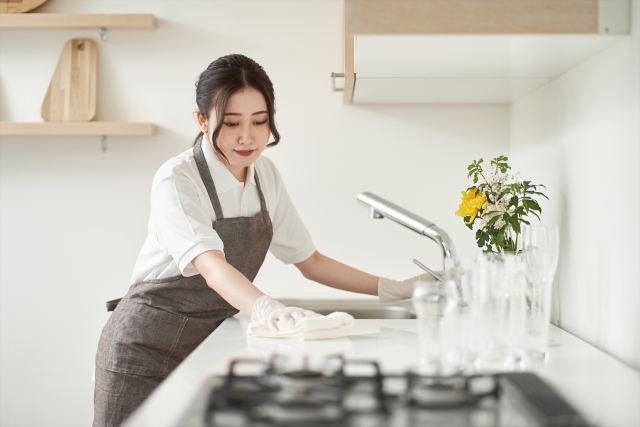 キッチンの調理台を丁寧に拭き上げるスタッフ